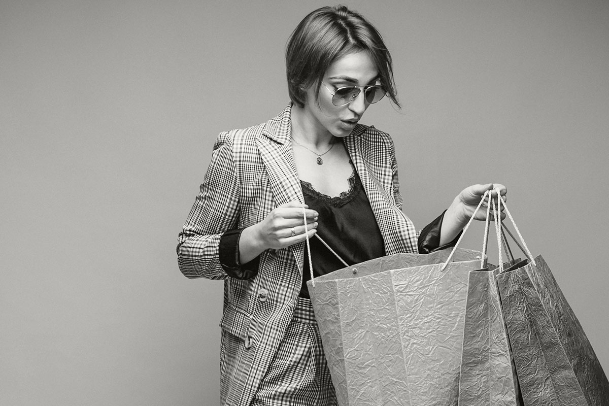 woman-with-shopping-bags-studio-yellow-background-isolated